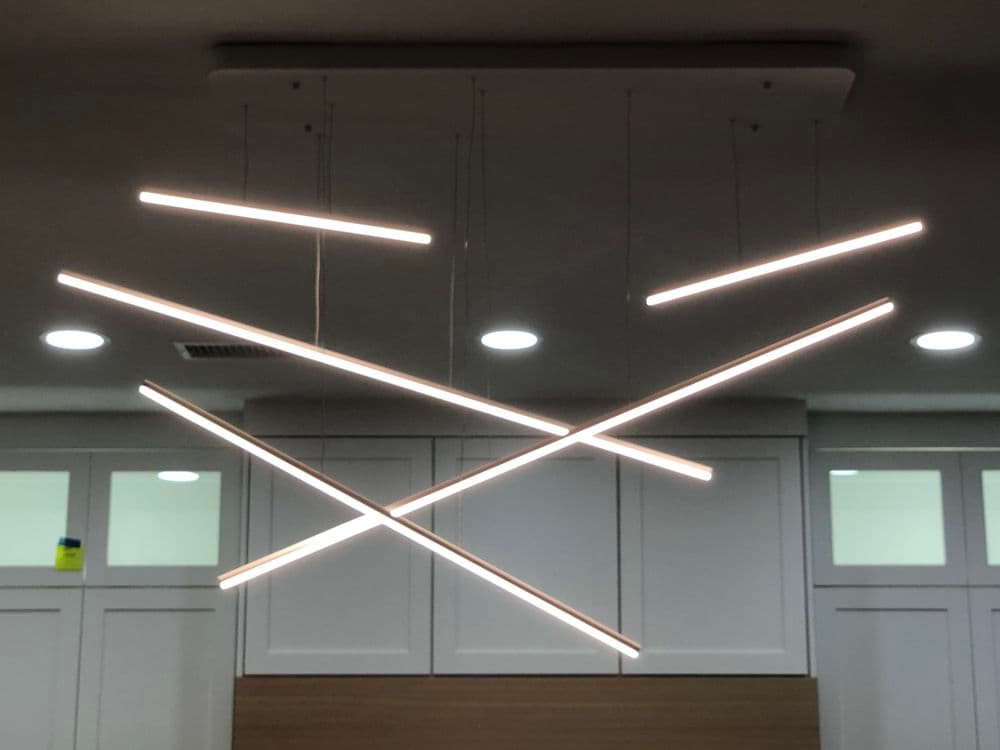 Modern ceiling light fixture with linear LED design in contemporary interior setting.